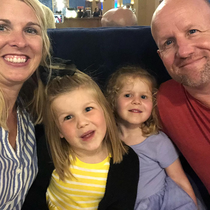 Brad Loheide with his wife and two daughters smiling for a selfie