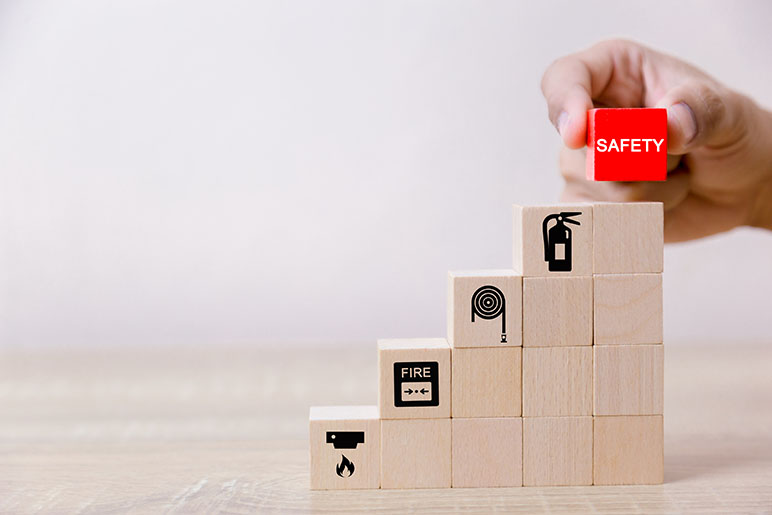 Building blocks with fire safety symbols on them and the top block is red with the word