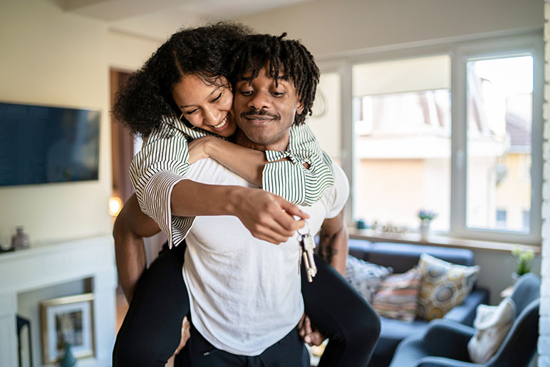 Couple hugging with their new apartment keys in hand