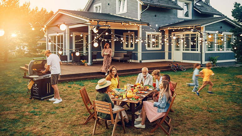 Family in their backyard enjoying dinner and playing in the yard