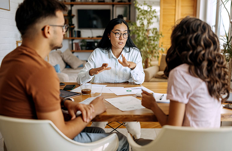 Father and teen daughter talking to an insurance agent about cheap car insurance for first time drivers