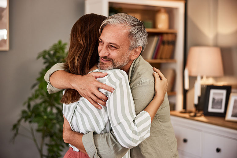 Older father hugging his daughter who may be his beneficiary