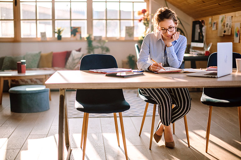 Young woman sitting at her desk while working from home