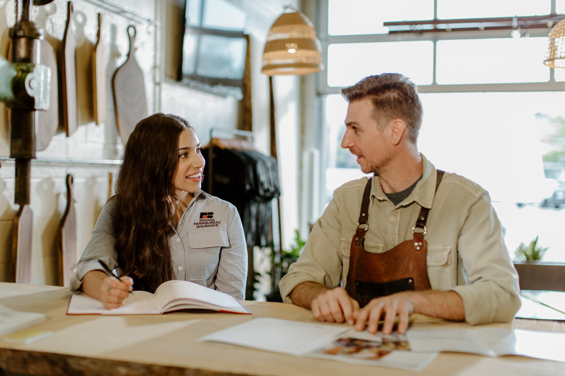 Business shop owner talking to an insurance agent.