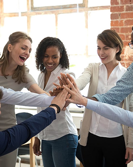 7 employees high fiving in a circle looking happy and celebrating